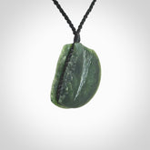 This piece is a contemporary disc pendant hand carved in New Zealand jade.